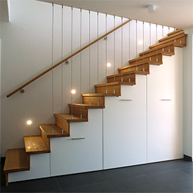 Eine Treppe mit Schrankunterbau führt auf die Schlafebene. 
